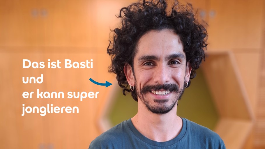 Ein Mann mit dunklem, lockigem Haar und einem Bart lächelt. Text: "Das ist Basti und er kann super jonglieren