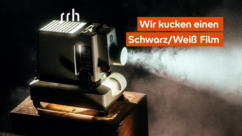 Ein Projektor steht auf einem Tisch, mit Dampf im Hintergrund.