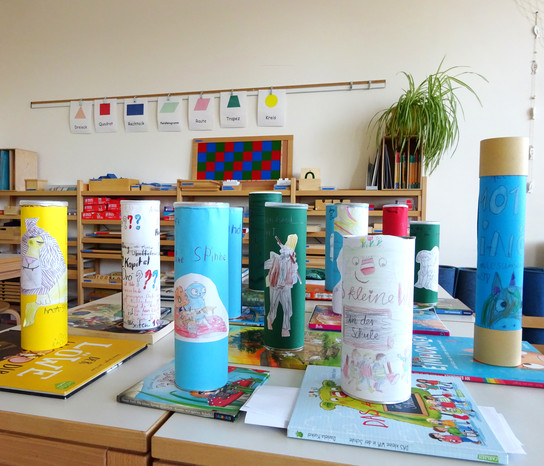 Ein Klassenzimmer mit bunt dekorierten Zylindern und Lehrmaterialien.